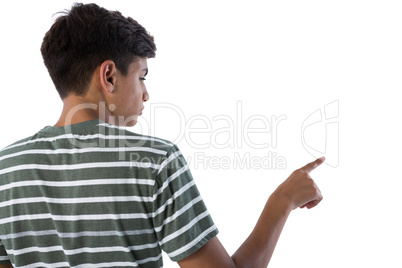 Teenage boy pressing an invisible virtual screen against white background