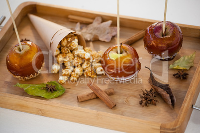 Popcorn, apple and apise on wooden tray