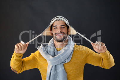 Portrait of smiling man holding wooly hat