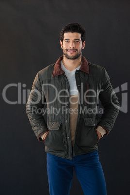 Smiling man posing against black background