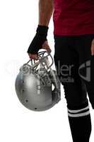 Cropped image of American football player holding helmet