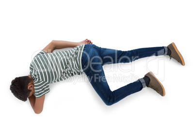 Teenage boy lying on white background