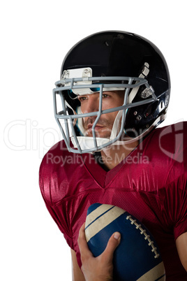 American football player wearing helmet holding ball