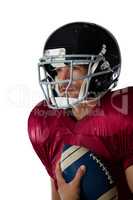 American football player wearing helmet holding ball