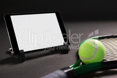 Close up of digital tablet by tennis racket and ball