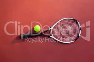 Overhead view of fluorescent yellow tennis ball on racket