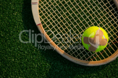 Overhead view of tennis ball with bandage on racket