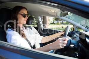 Senior woman looking into rear view mirror while driving a car
