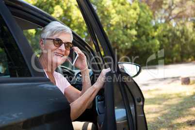 Senior woman talking on mobile phone in car