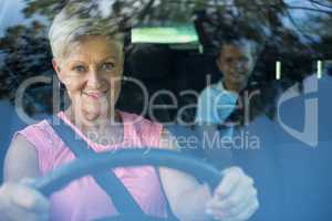 Grandmother driving a car while grandson sitting in the back seat
