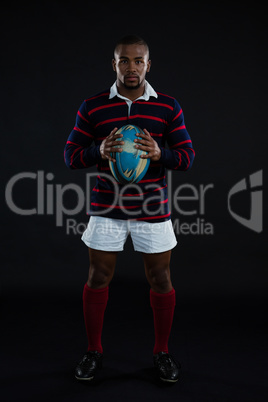 Portrait of sportsman holding rugby ball