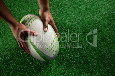 High angle view of hands holding rugby ball