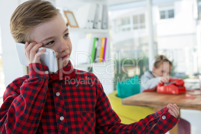 Boy as business executive talking on mobilephone