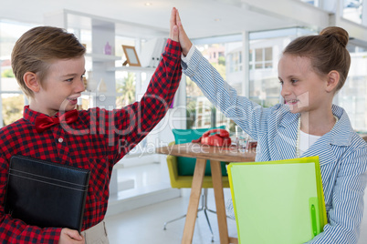 Kids as business executives giving high five to each other