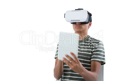 Teenage boy using virtual reality headset and digital tablet