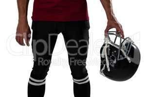 Midsection of football holding helmet