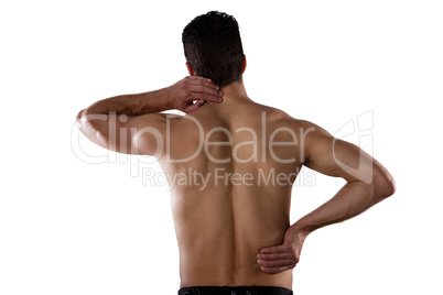 Rear view of shirtless sportsperson suffering from pain