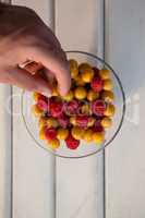 Hand picking berry from bowl