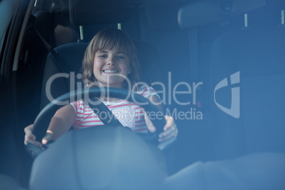 Happy teenage girl driving a car