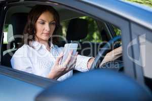 Woman using mobile phone while driving a car