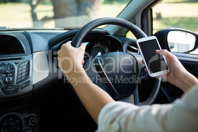 Woman using mobile phone while driving a car