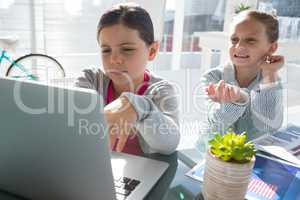 Kids as business executives discussing over laptop