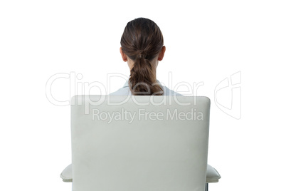 Female executive relaxing on chair against white background