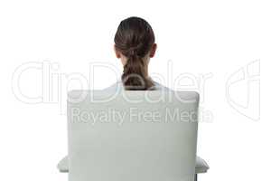 Female executive relaxing on chair against white background