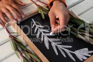 Hand drawing leaves on slate