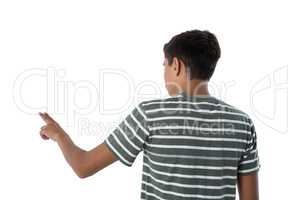 Teenage boy pressing an invisible virtual screen against white background