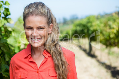 Portrait of smiling woman standing in vineyard