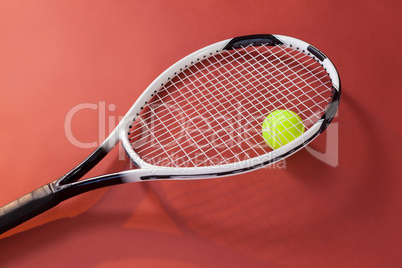 High angle view of fluorescent yellow ball with tennis racket