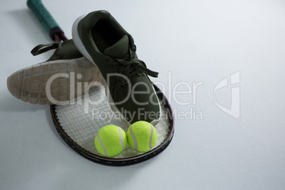 High angle view of sports shoe with tennis ball and racket