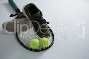 High angle view of sports shoe with tennis ball and racket