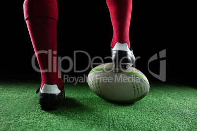 Close up of sportsperson stepping on rugby ball