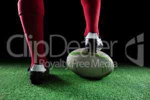 Close up of sportsperson stepping on rugby ball
