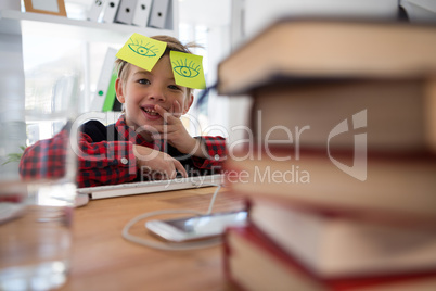 Boy as business executive with sticky notes on his eyes