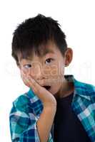 Astonished boy standing against white background