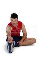 Full length of sports player stretching legs while exercising