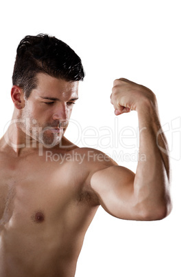 Shirtless American football player flexing muscles