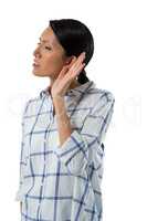 Female executive listening secretly with hands behind her ears