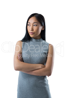 Woman standing with arms crossed against white background