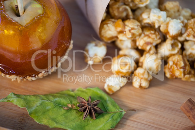 Popcorn, apple and apise on wooden table