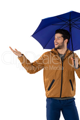 Smiling man standing under umbrella