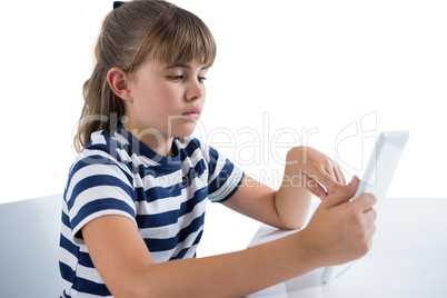 Cute girl using digital tablet at table