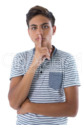 Portrait of teenage boy with finger on lips