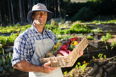 Portrait of happy man holding a basket of fresh vegetables