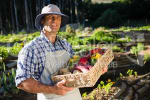 Portrait of happy man holding a basket of fresh vegetables