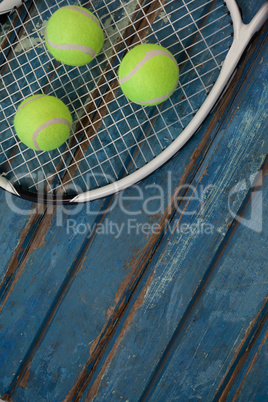 High angle view of fluorescent yellow balls on tennis racket