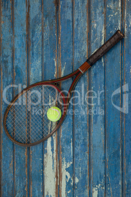Overhead view of brown tennis racket with ball